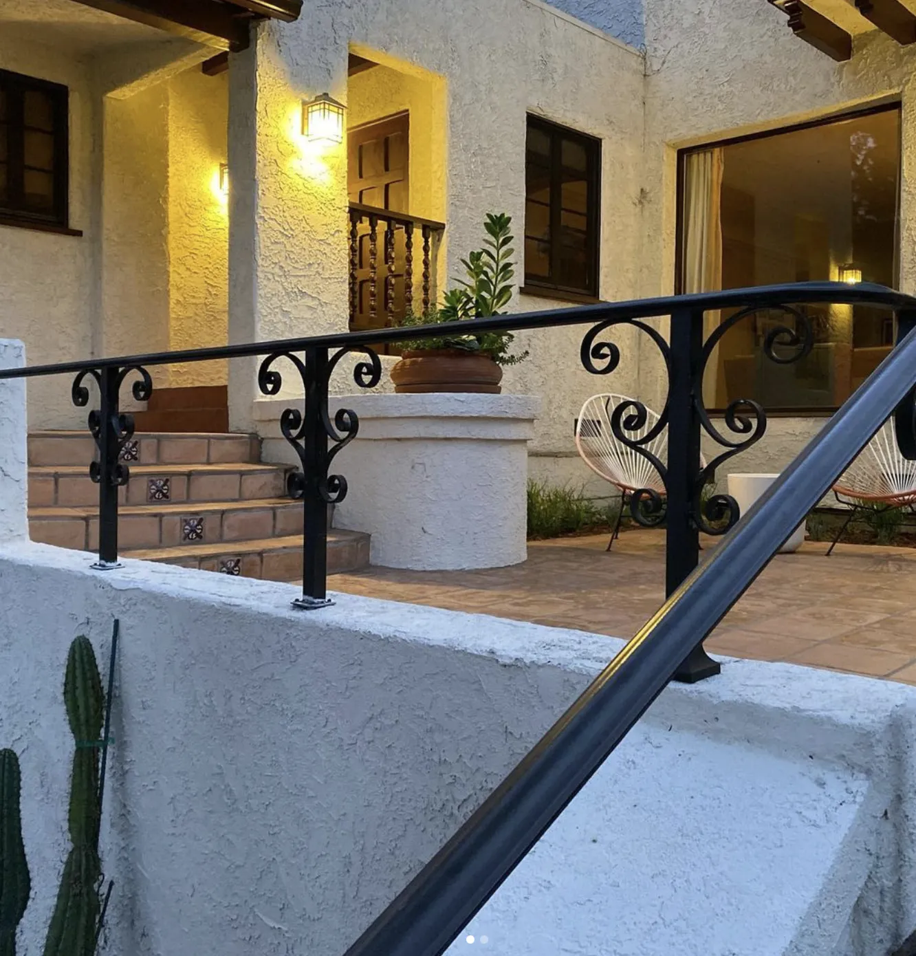 Black iron stair railing on a stucco house